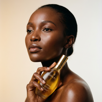 Modèle peau dark tenant le flacon Lumina de GWLAA, huile de soin universel nourrissante pour le visage, le corps et les cheveux.